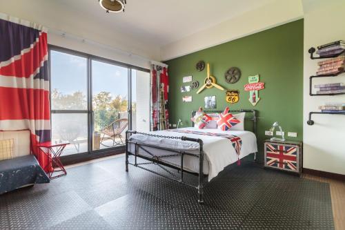 安平的住宿－異宿風巢景觀旅店 ，一间卧室设有绿色的墙壁、一张床和窗户