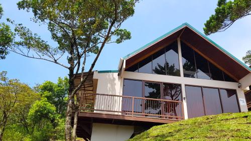 a house on a hill with a balcony at Green Forest Rustic Houses in Monteverde Costa Rica