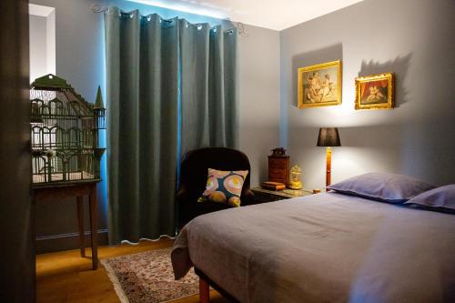 a bedroom with a bed and a chair next to a window at Côté Jardin, Chambres d’hôtes B&B in Le Pont-de-Beauvoisin