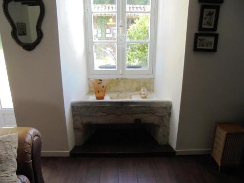 un salon avec une cheminée et une fenêtre dans l'établissement La Coquille Cottage, à Pillac