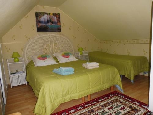 um quarto com 2 camas e lençóis verdes em les raseries em La Chapelle-dʼAligné