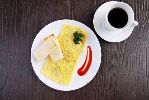 a white plate with a piece of food and a cup of coffee at GQ Plaza in Kalibo
