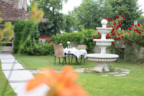 a fountain in a garden with a table and chairs at Hotel Zum Goldenen Hirschen in Freistadt