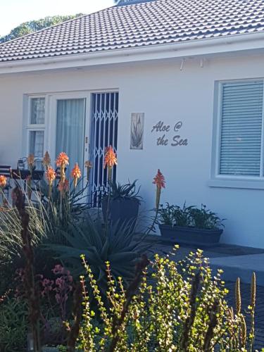 Una casa blanca con un letrero que lee, da el paso. en Aloe @ the Sea, en Mossel Bay