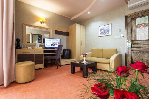 a living room with a couch and a desk with a computer at Balneo Complex & Spa Aquatonik in Velingrad