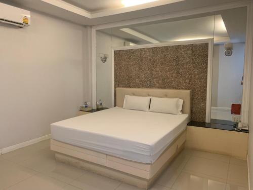 um quarto com uma grande cama branca num quarto em Merry Resort Photaram em Ban Khlong Ta Khot