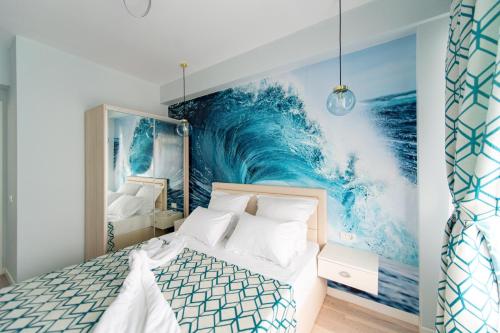 a bedroom with a large wave mural on the wall at Summerland Sunrise Apartments in Mamaia