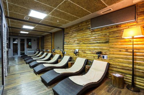 a row of chairs lined up against a wooden wall at Balneo Complex & Spa Aquatonik in Velingrad
