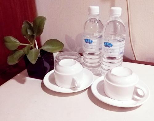 two cups and two bottles of water on a table at Harbour Inn in Melaka