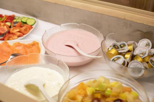a counter topped with bowls of different types of food at Hotel Zum Goldenen Hirschen in Freistadt