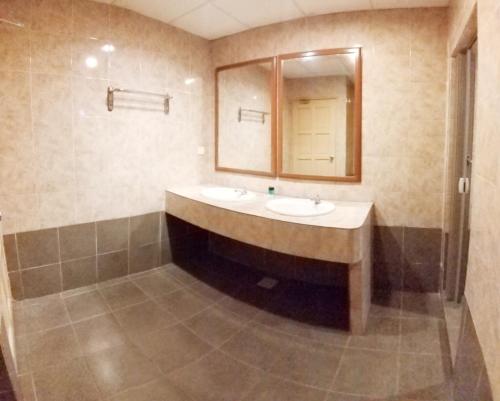 a bathroom with two sinks and a mirror at Harbour Inn in Melaka
