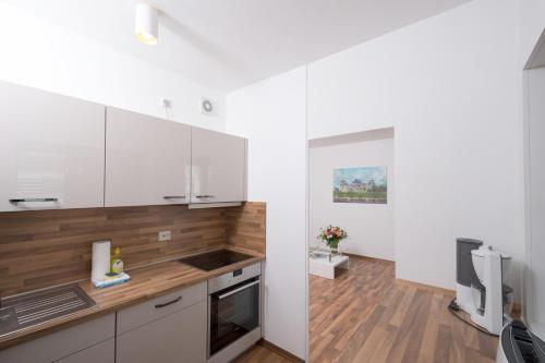 a kitchen with white cabinets and a wooden floor at Apartments am Brandenburger Tor in Berlin