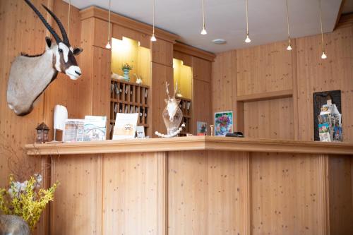 a bar in a store with a fake deer head on the wall at Hotel Zum Goldenen Hirschen in Freistadt