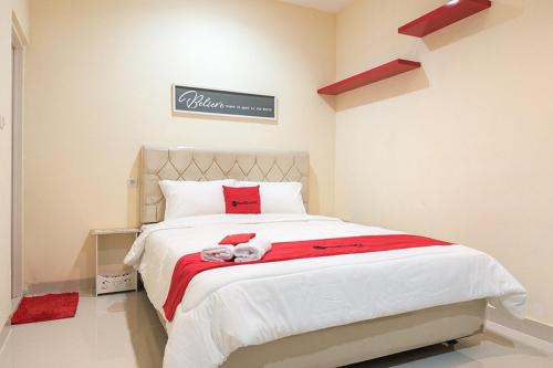 a bedroom with a large bed with a red blanket at RedDoorz At Tebet Barat 2 in Jakarta