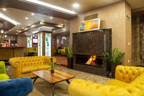 a living room with yellow furniture and a fireplace at Balneo Complex & Spa Aquatonik in Velingrad