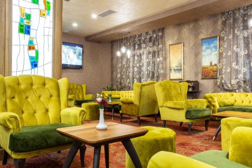 a waiting room with yellow chairs and a table at Balneo Complex & Spa Aquatonik in Velingrad
