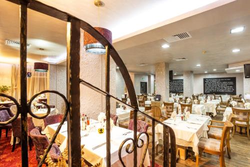 a dining room with white tables and chairs at Balneo Complex & Spa Aquatonik in Velingrad