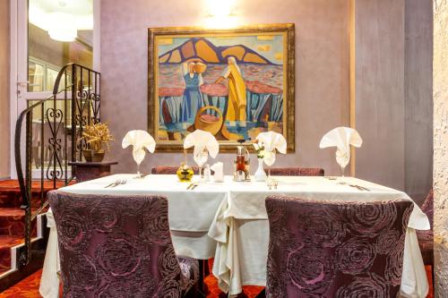 a dining room with a table and a painting at Balneo Complex & Spa Aquatonik in Velingrad