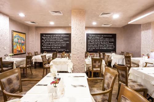 a dining room with tables and chairs and chalkboards at Balneo Complex & Spa Aquatonik in Velingrad