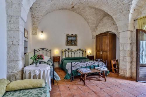 a bedroom with a bed and a table in a room at Masseria Casina Vitale in Ceglie Messapica