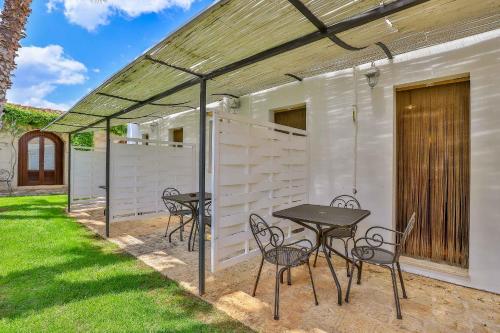 a patio with a table and chairs and a fence at Masseria Casina Vitale in Ceglie Messapica
