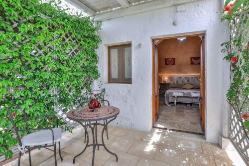 a patio with a table and a green wall at Masseria Casina Vitale in Ceglie Messapica