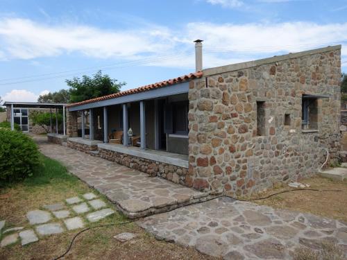 a stone house with a stone wall at To Spitaki House in Perdika