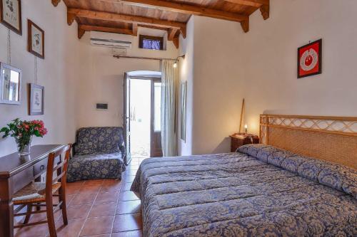 a bedroom with a bed and a desk and a chair at Masseria Casina Vitale in Ceglie Messapica