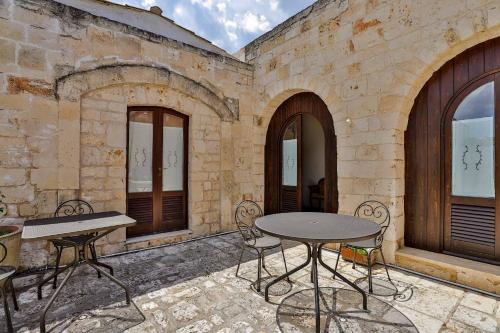 a patio with two tables and chairs in front of a building at Masseria Casina Vitale in Ceglie Messapica