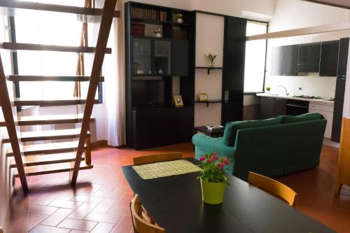 uma sala de estar com uma mesa e um sofá verde em Santa Croce Exclusive em Florença