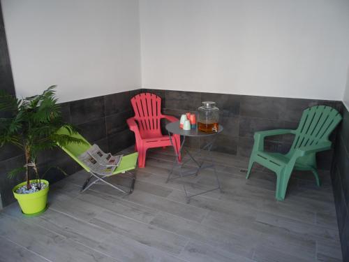 three chairs and a table on a patio at Chante Grelet in Châtel-Guyon