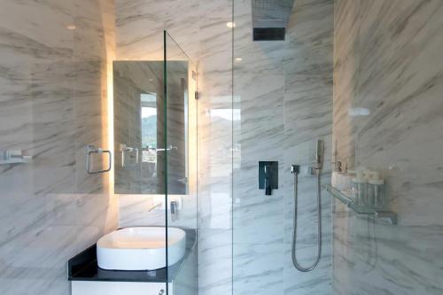 a bathroom with a shower with a sink and a toilet at Oceana Sea View Apartments - Kamala Beach in Kamala Beach