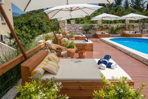 a patio with umbrellas and a swimming pool at Kis Residence - Adults Only in Korčula