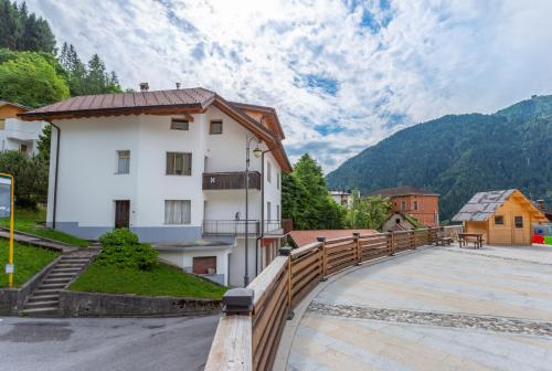 a white building with a wooden fence around it at Albergo Diffuso Ravascletto in Ravascletto