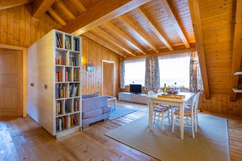 a living room with a table and a book shelf at Albergo Diffuso Ravascletto in Ravascletto