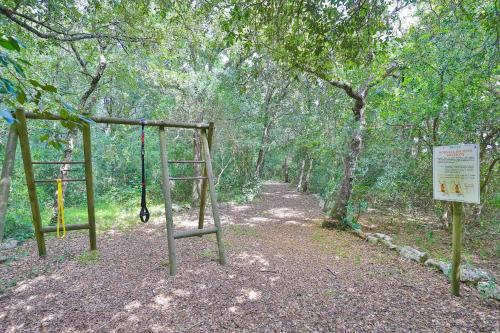 a park with a swing and a sign in the woods at Masseria Casina Vitale in Ceglie Messapica