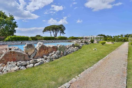 a rock retaining wall next to a swimming pool at Masseria Casina Vitale in Ceglie Messapica