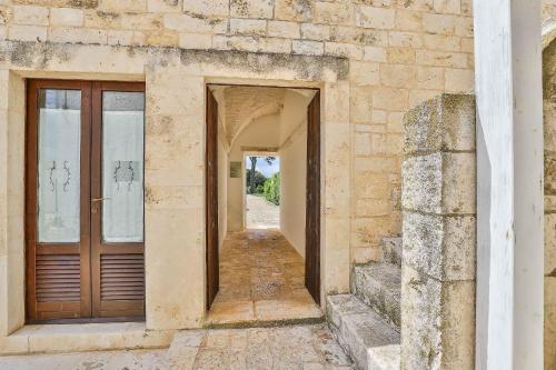 an entrance to a stone building with a wooden door at Masseria Casina Vitale in Ceglie Messapica