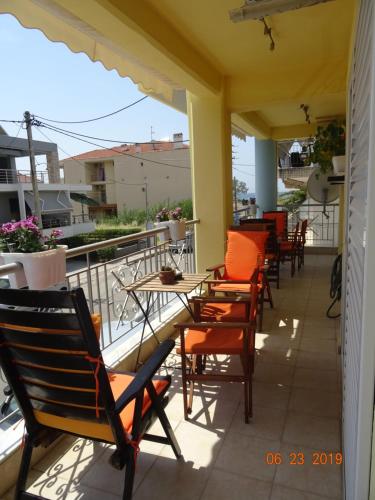 a patio with chairs and tables on a balcony at Paralia in Flogita