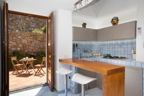 eine Küche mit einer Theke und einem Tisch mit Stühlen in der Unterkunft Montebosco Luxury Country House in Piano di Sorrento