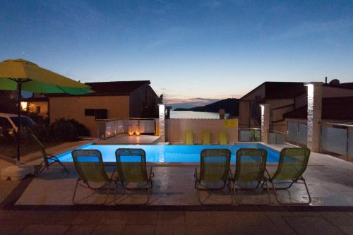 a group of chairs sitting around a swimming pool at Villa Sunset in Rogoznica