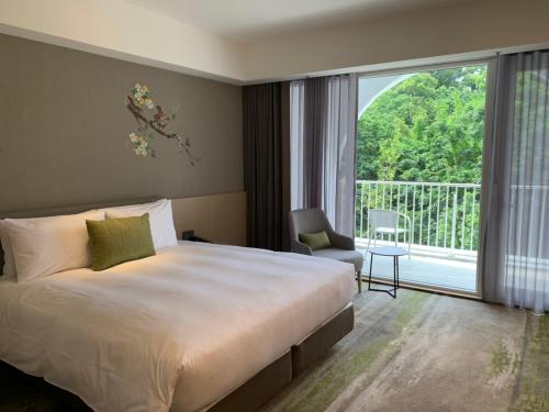 a hotel room with a bed and a large window at Golden Tulip FAB Hotel New Taipei in Tamsui