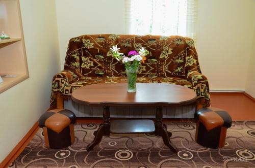 a table with a vase of flowers on a couch at Narek B&B in Goris