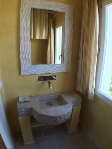 a bathroom with a stone sink and a mirror at Casa Nina in Gabicce Mare