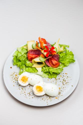 une assiette de nourriture avec des œufs et de la salade dessus dans l'établissement Villa V, à Braşov