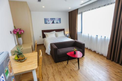 a bedroom with a bed and a couch and a table at HNC Premier Hotel & Residences in Hanoi