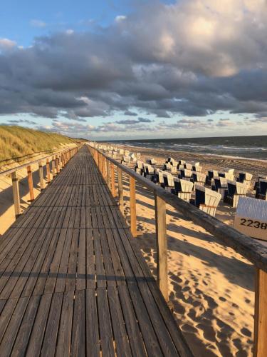 een promenade met stoelen op het strand bij Dein Sylt in Westerland