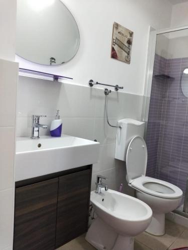 a bathroom with a toilet and a sink and a mirror at La Santera in Marina di Davoli
