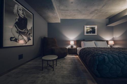 a bedroom with a bed and a chair and a couch at node hotel in Kyoto