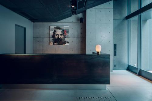 a reception desk in a room with a painting on the wall at node hotel a Member of Design Hotels in Kyoto